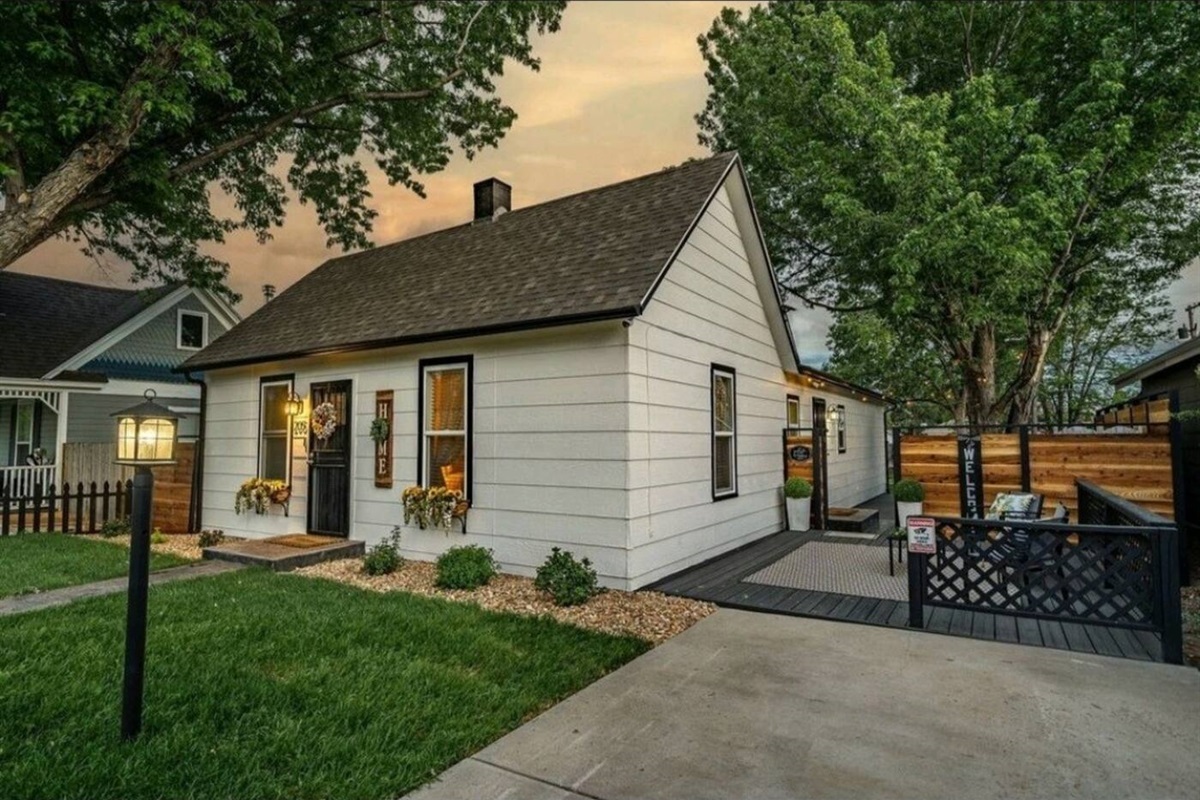 exterior of a vacation rental. small home with white siding and large backyard.